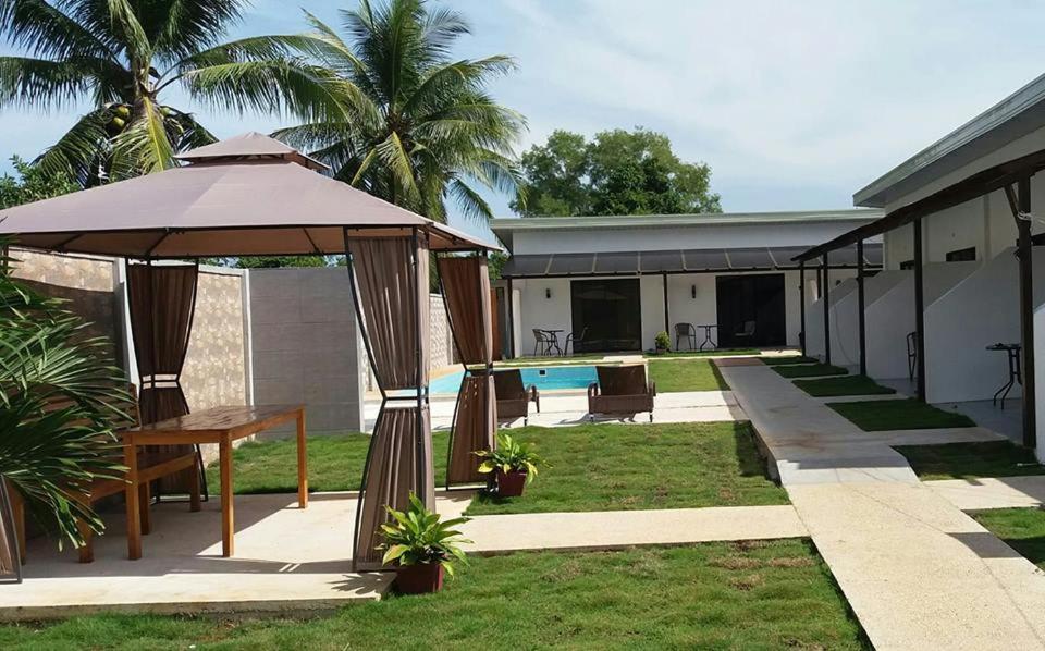 a patio with an umbrella and a table and a pool at panglao moravian apartments in Panglao Island
