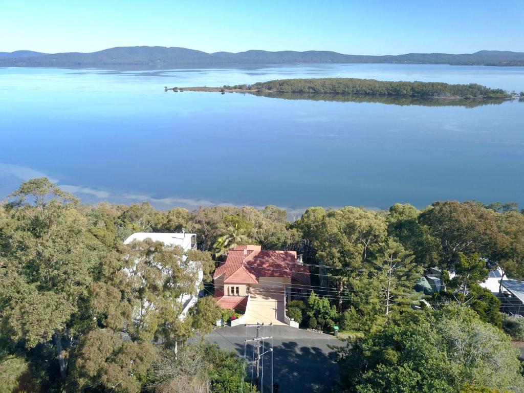 Vue aérienne d'une maison sur la rive d'un lac dans l'établissement Booti Booti Chateau Lakeside, à Booti-Booti