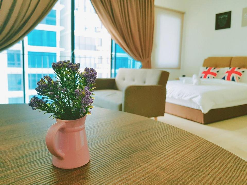 a pink vase with flowers on a table in a room at Simplicity Cozy For 2 -Trefoil Setia Alam- Near Setia City Mall-Setia Convention Centre in Shah Alam