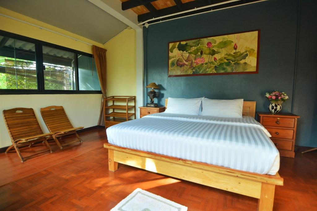 1 dormitorio con 1 cama y 2 sillas en The Corner's unique house en Chiang Mai