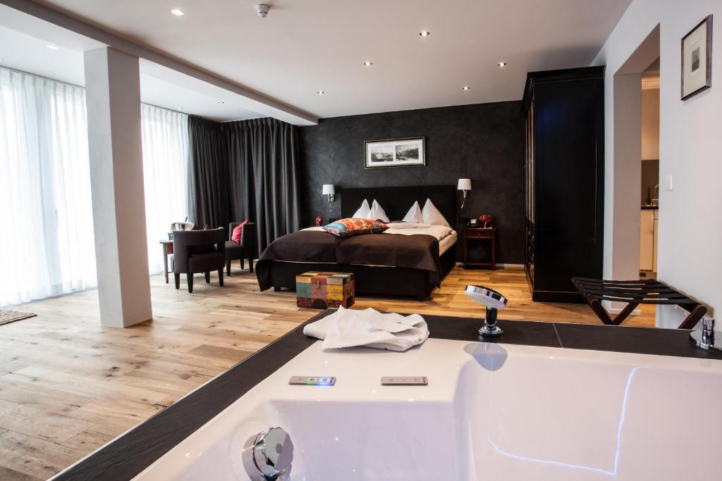 a hotel room with a bed and a bathroom at Hotel Riviera Loft in Weggis