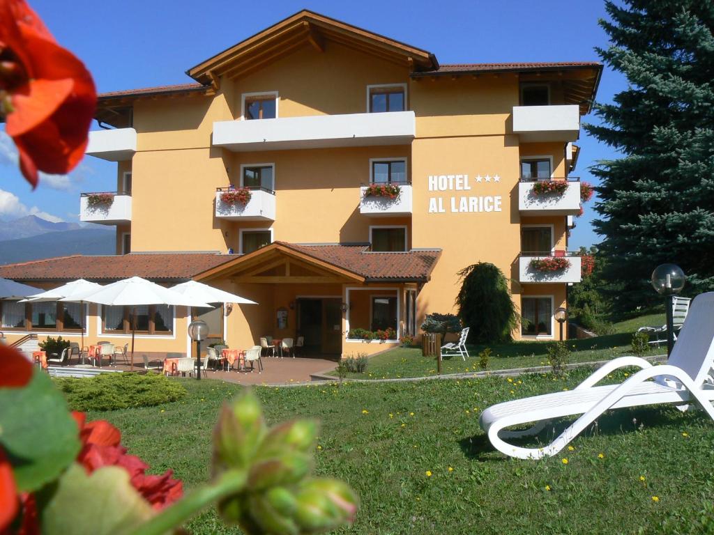 een uitzicht op een hotel met stoelen en een gebouw bij Hotel & Appartamenti Al Larice in Ronzone