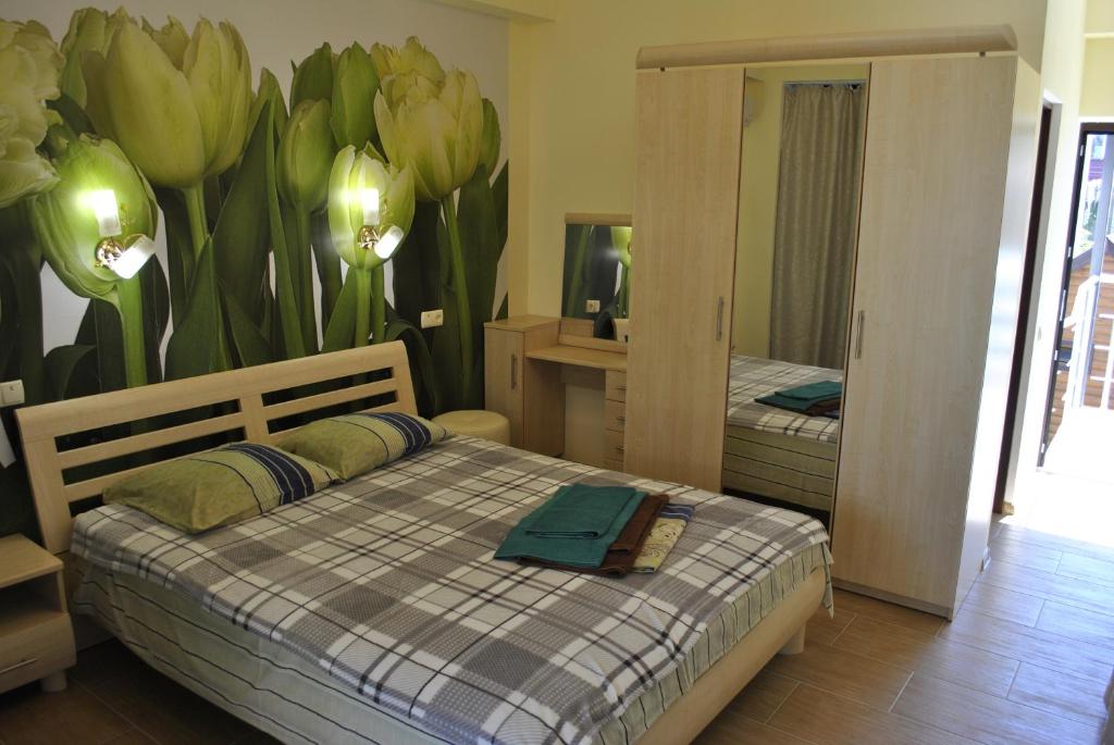 アルシタにあるComfortのベッドルーム1室(ベッド2台付)が備わります。花の壁画が飾られています。