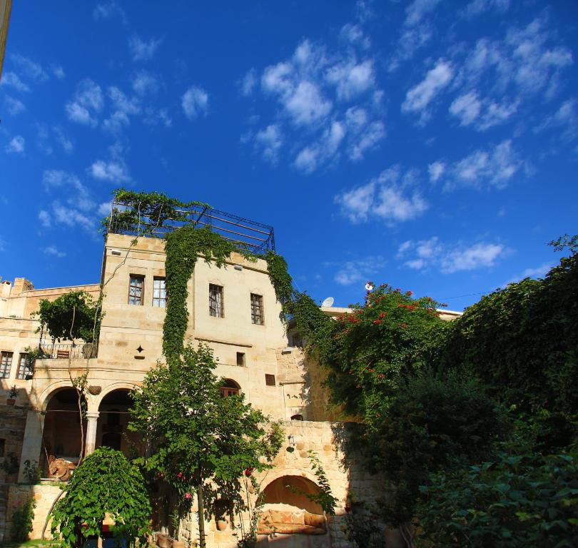 a building with ivy growing on the side of it at Selcuklu Evi Cave Hotel - Special Category in Urgup