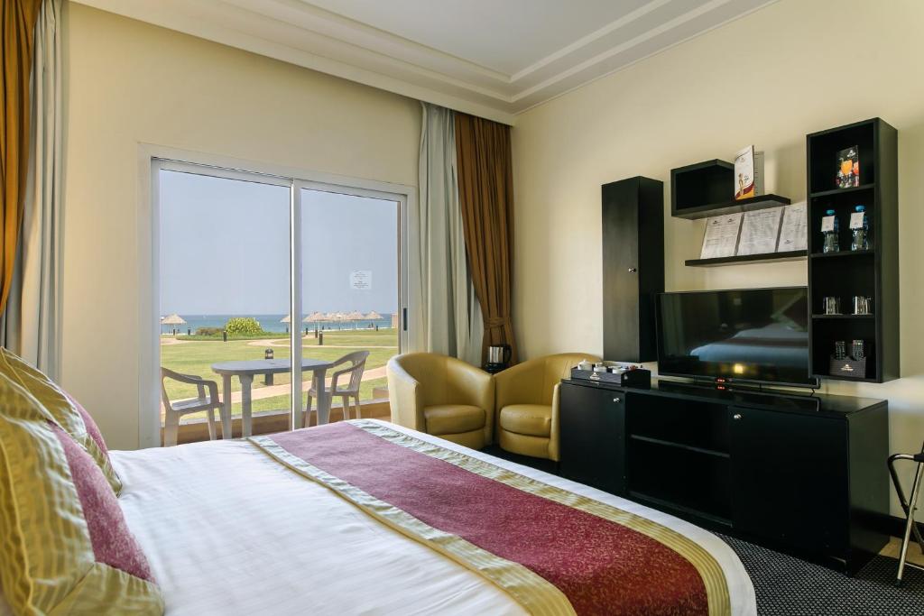 Royal Beach Hotel & Resort tesisinde bir odada yatak veya yataklar