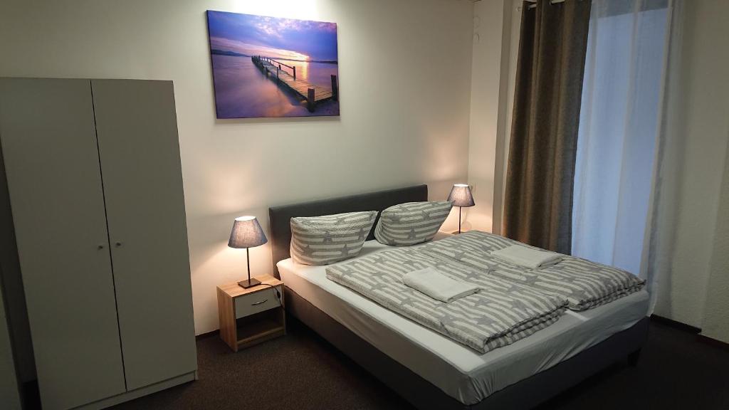 ニュルンベルクにあるNürnberg City Apart-のベッドルーム1室(ベッド1台付)が備わります。壁に絵が飾られています。