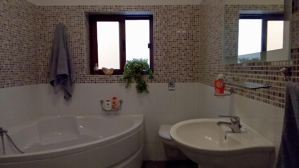 Baño blanco con bañera y lavamanos en Rubis, en Victoria