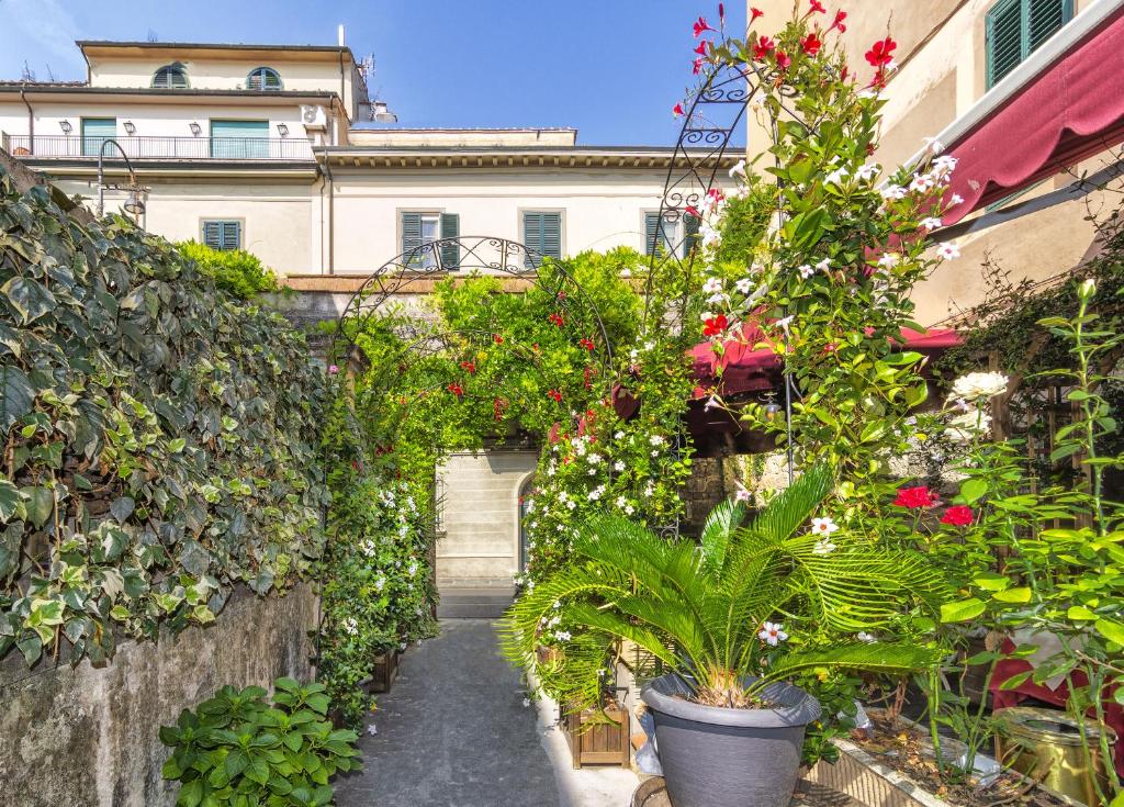 um corredor com plantas e flores num edifício em Hotel Amalfitana em Pisa