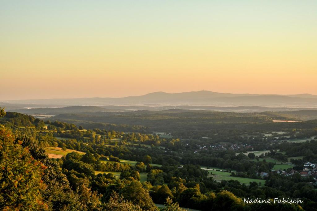 una vista de un valle al atardecer con montañas en el fondo en Ferienwohnung auf dem Pferdehof, en Schotten