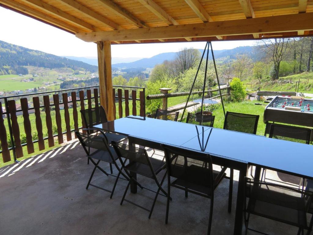 una mesa azul y sillas en un balcón con vistas en La Maison Jaune en Cleurie