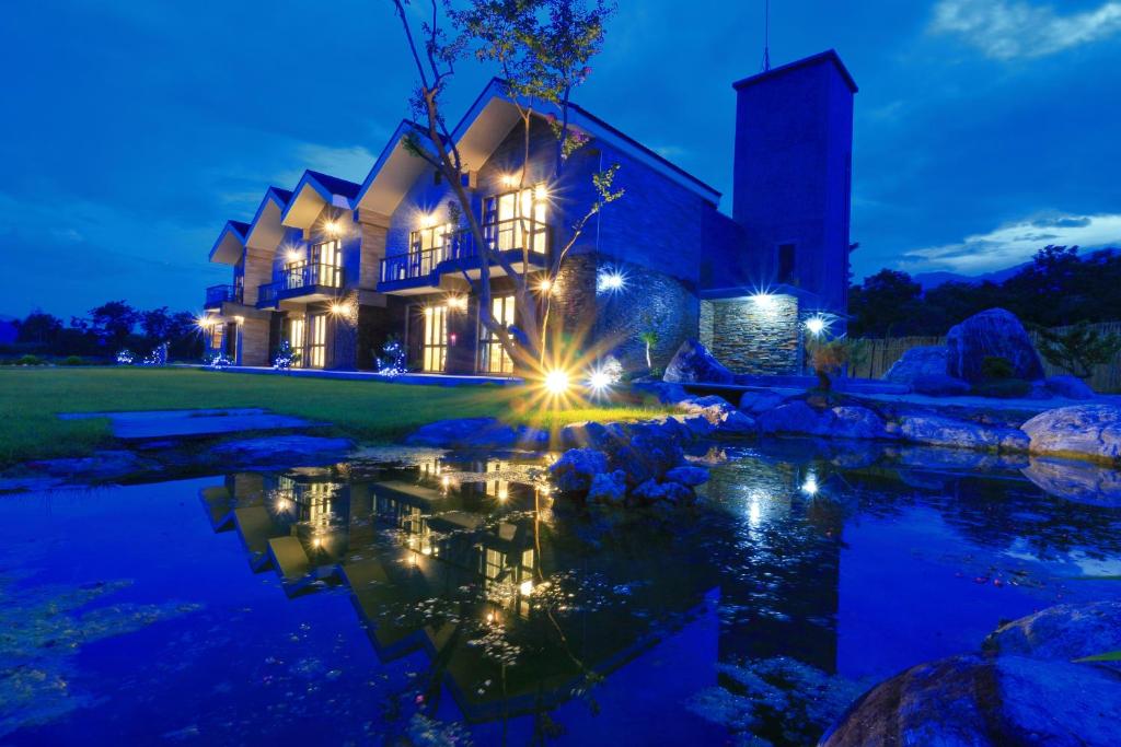 una casa con luces en el agua por la noche en Eastern love B&B, en Ruisui