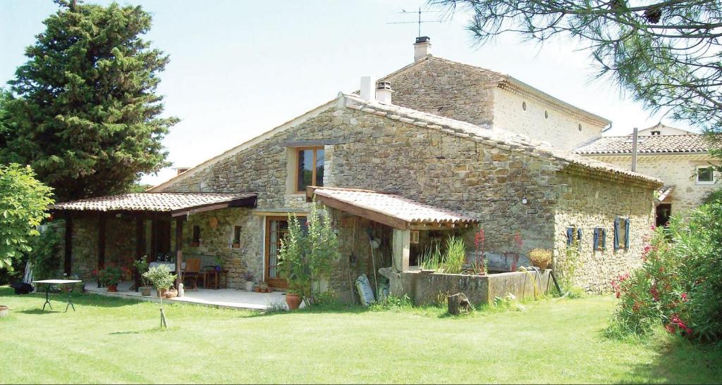 a large stone house with a grass yard at GITE LA FREYDIERE in La Bégude-de-Mazenc