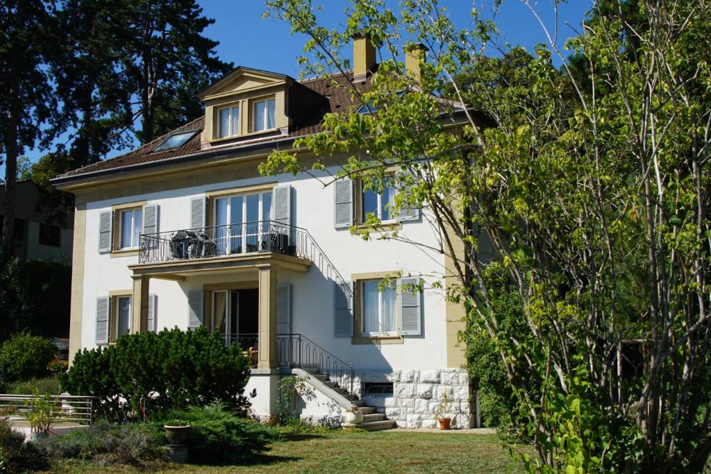 uma grande casa branca com uma varanda em Maujobia 31 em Neuchâtel