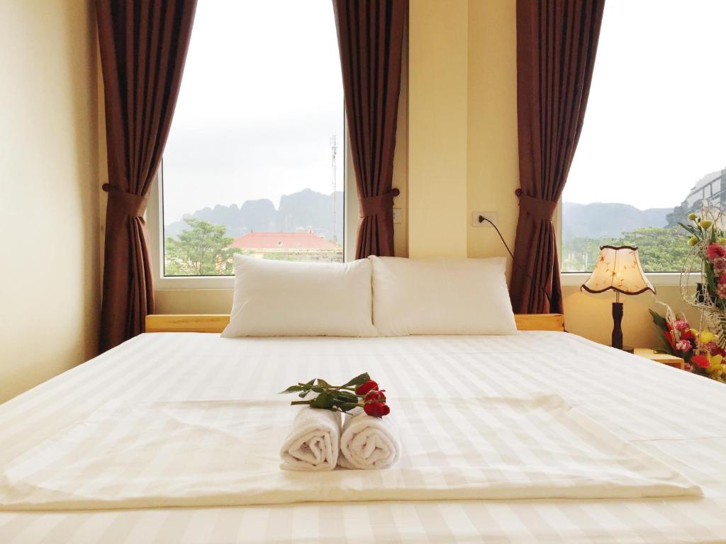 a bedroom with a bed with towels and a window at Ha Lan Homestay in Ninh Binh