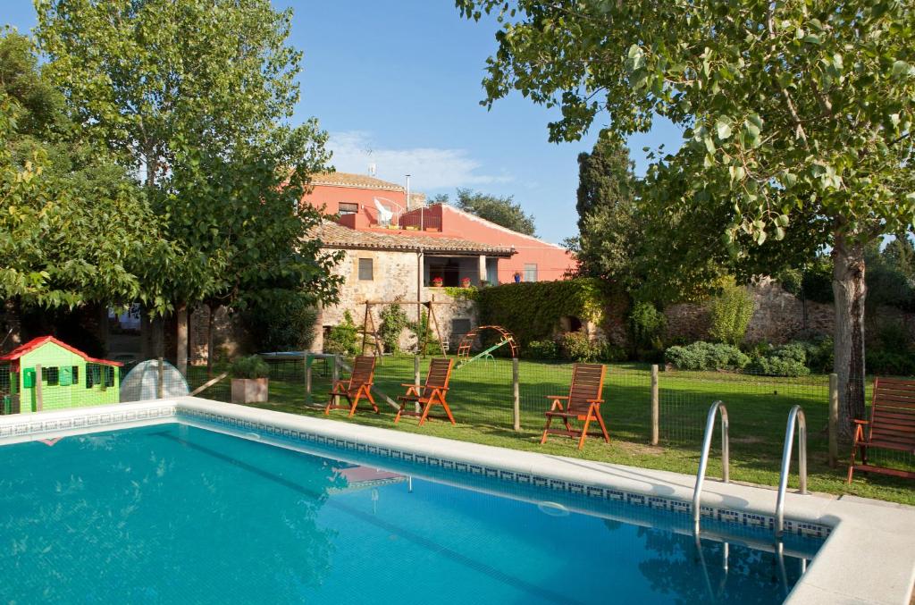 a swimming pool in front of a house at Turisme Rural Mas Masaller in Cruïlles