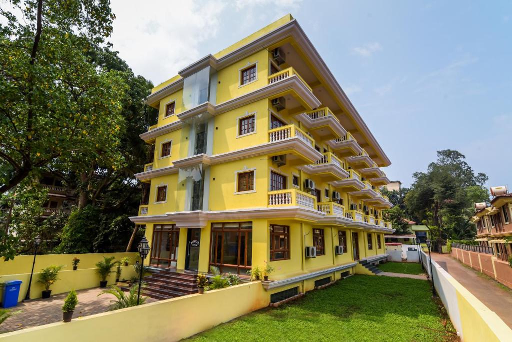 a yellow building with white trim at Sonikas Leisure in Candolim