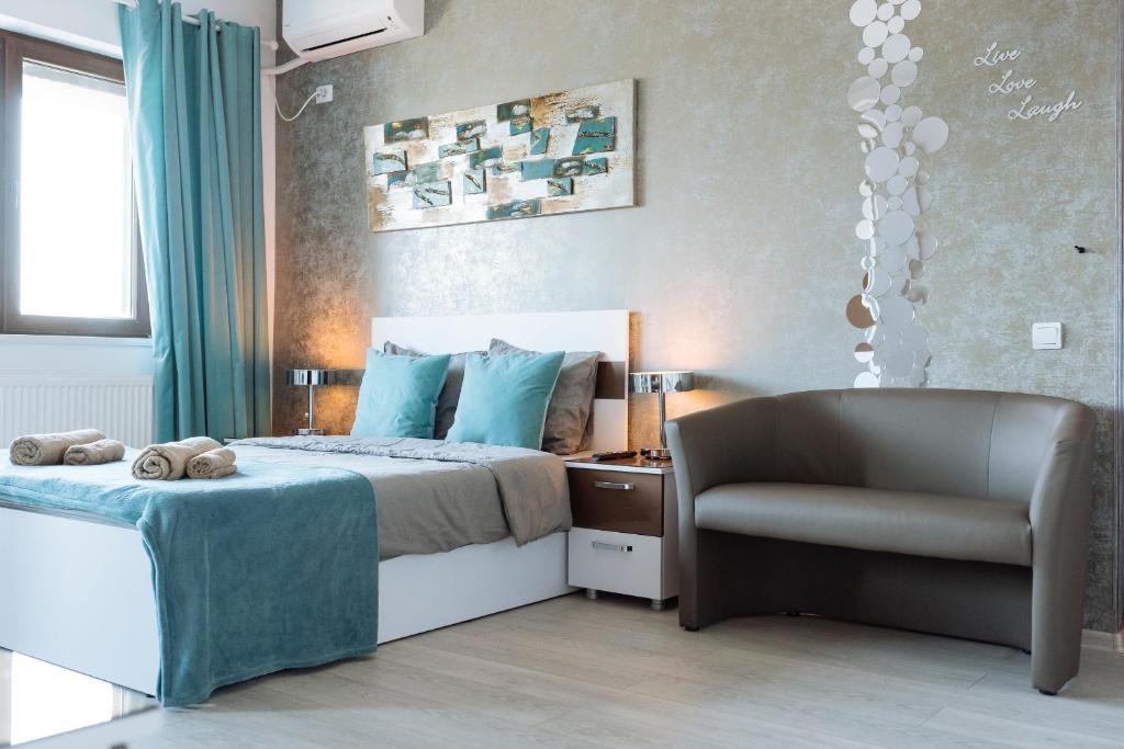 a bedroom with a bed and a chair at Luxury Flat 9 near Metro in Bucharest