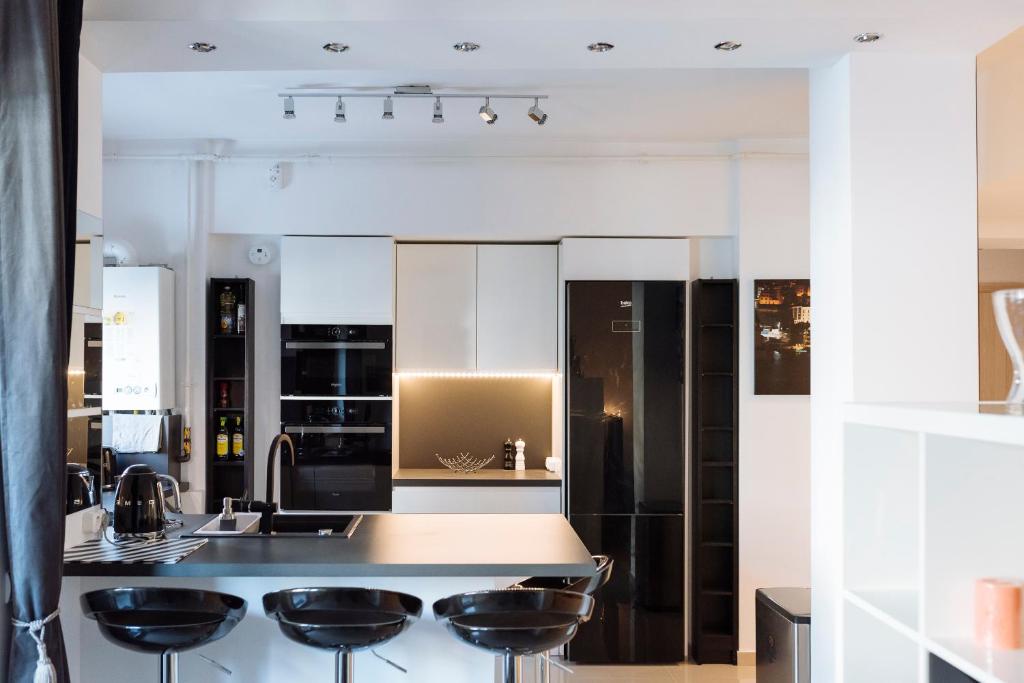 eine Küche mit weißen Schränken und schwarzen Geräten in der Unterkunft Luxury Flat 8 near Metro in Bukarest