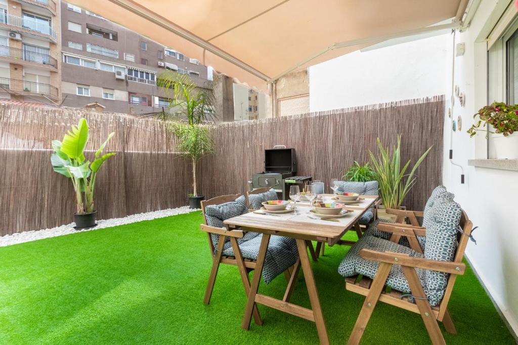 a patio with a table and chairs on grass at Stylish Apartment in Villajoyosa