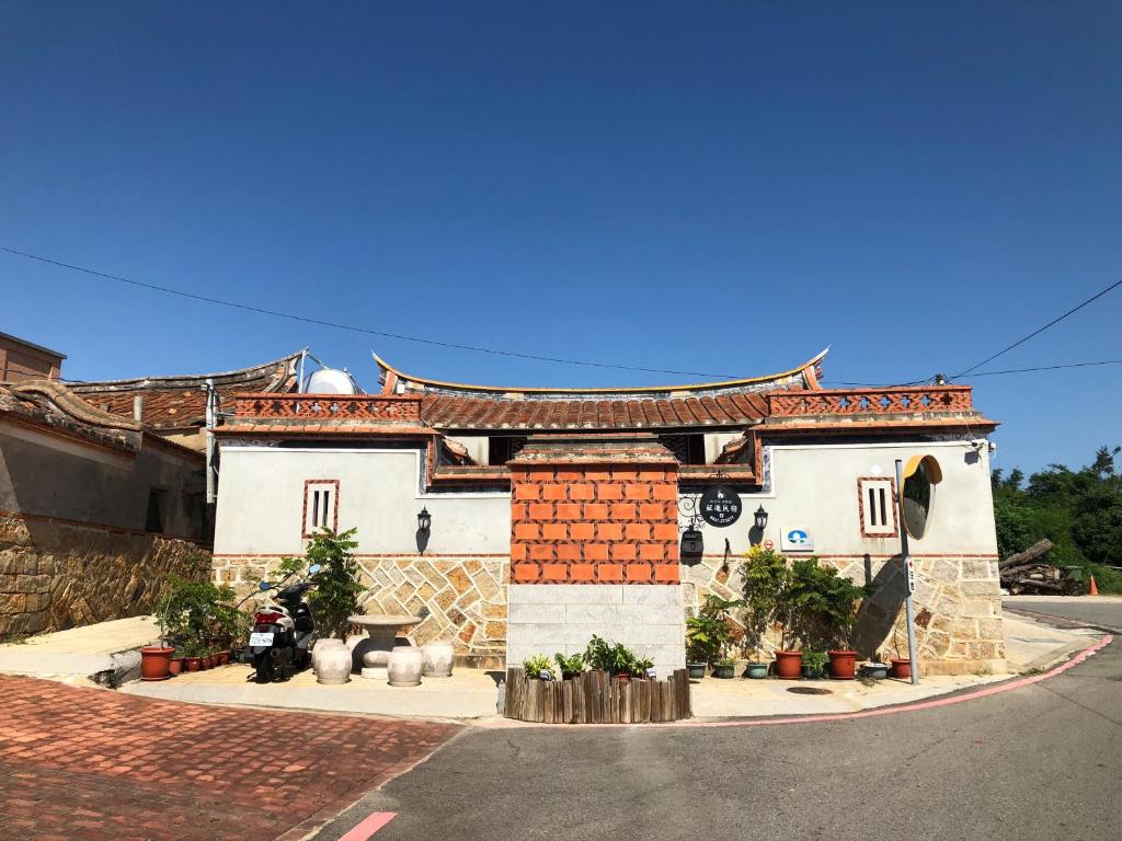 a building with an asian roof on a street at Relaxing INN Backpackers Warehouse in Jinning