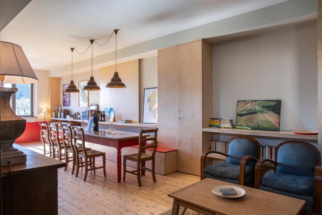 a kitchen and living room with a table and chairs at Borgo Argiano in Castelnuovo Berardenga