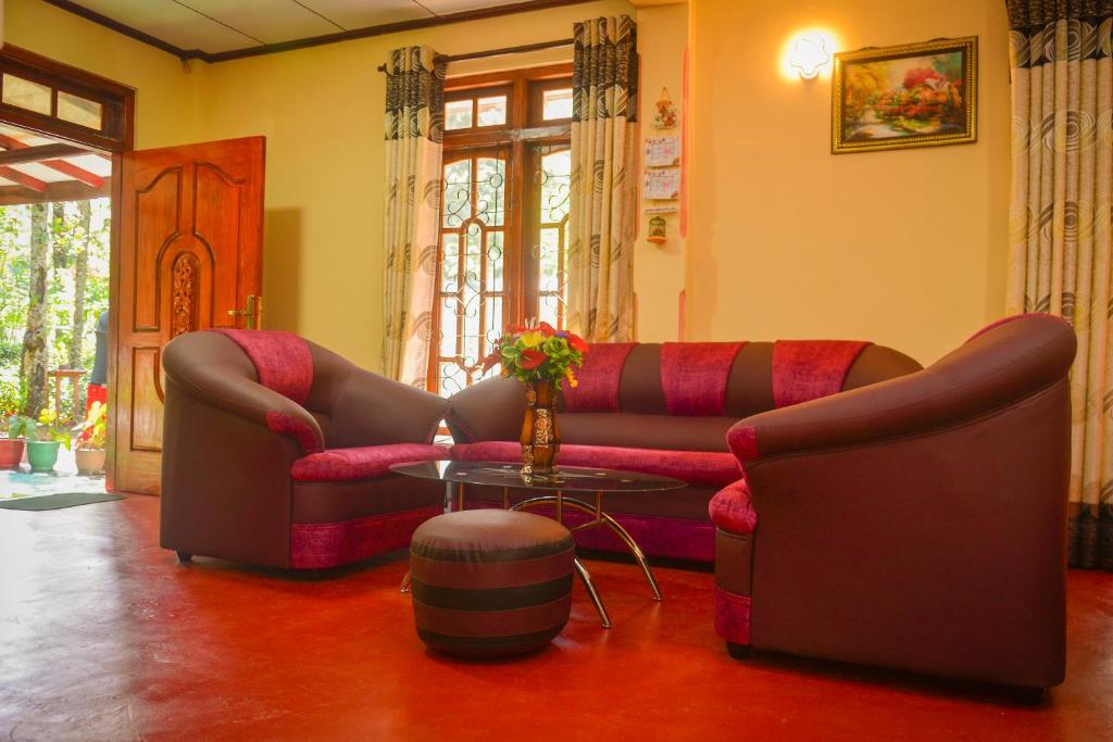 ein Wohnzimmer mit einem Sofa und einem Tisch in der Unterkunft Lak Sewana Home Stay in Kandy