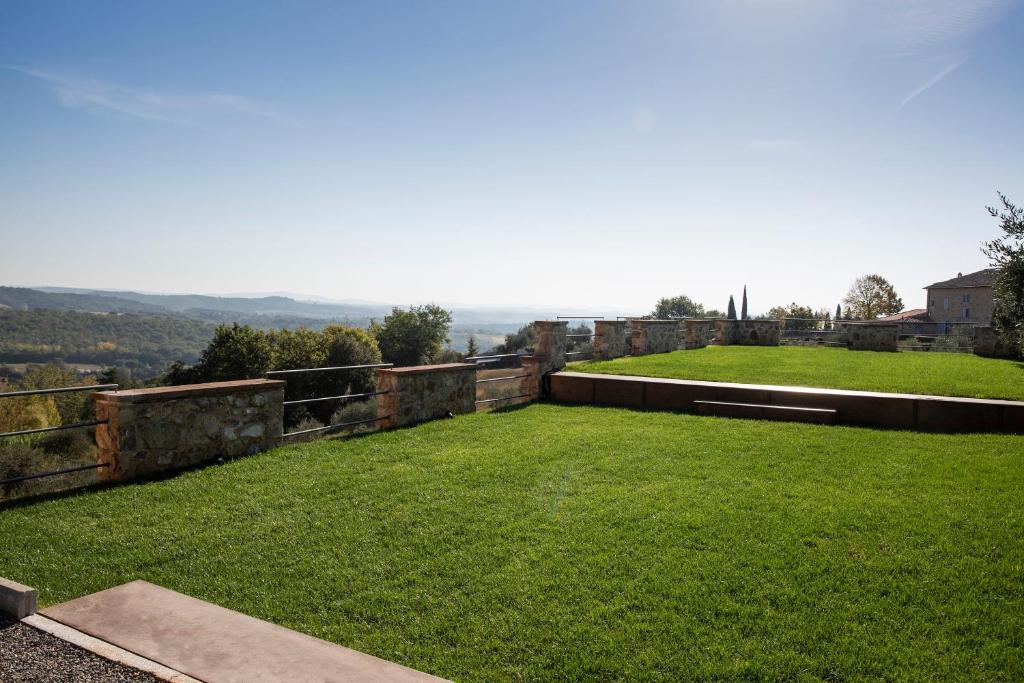 a large yard with green grass and a view at Borgo Argiano in Castelnuovo Berardenga