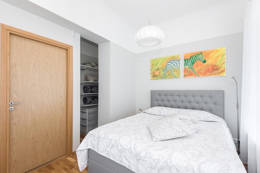 a white bedroom with a bed and a closet at Kuninga City Center Apartment in Pärnu