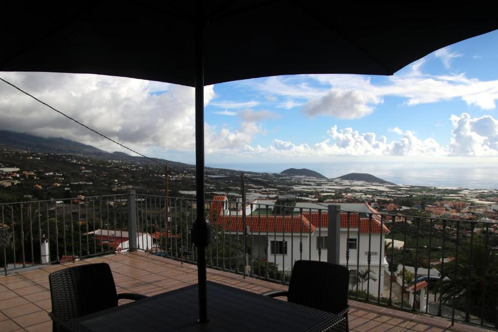 a table with an umbrella on top of a balcony at Casa Clotilde in Los Llanos de Aridane