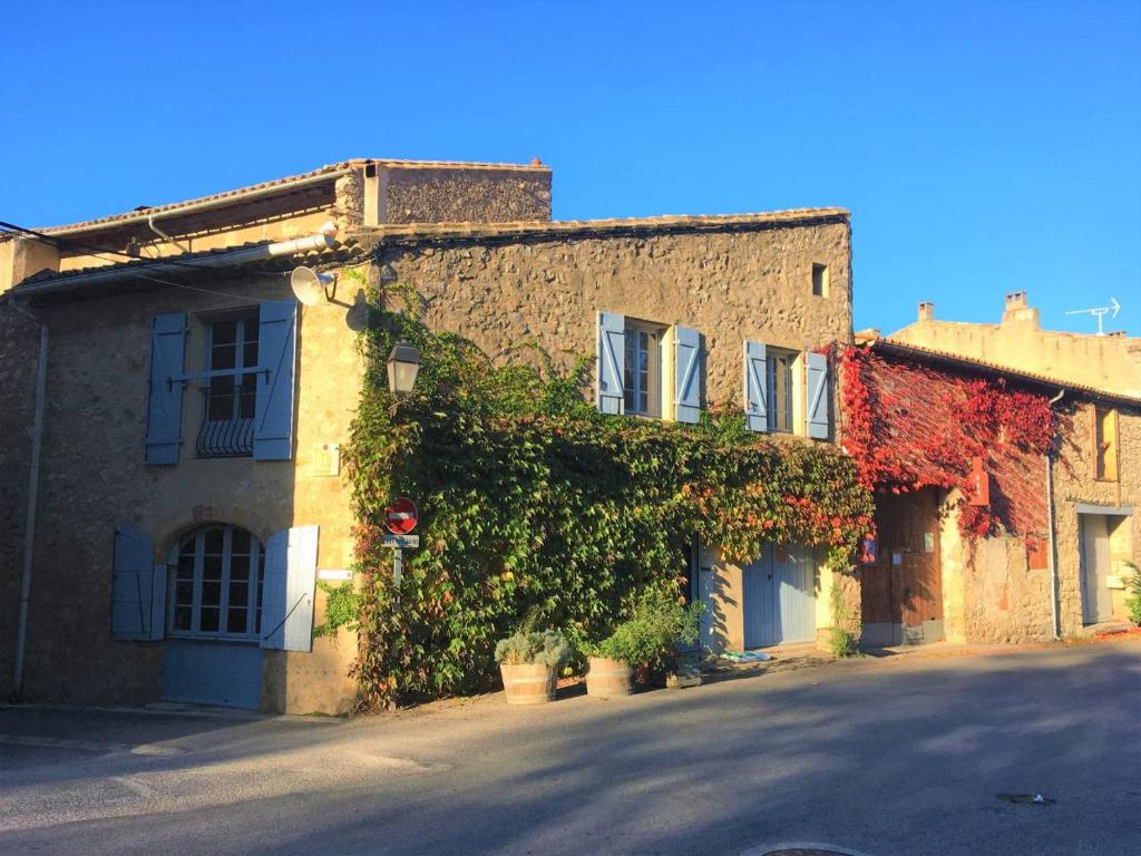 een stenen gebouw met planten aan de zijkant bij La maison Vigne Vierge in Lagrasse