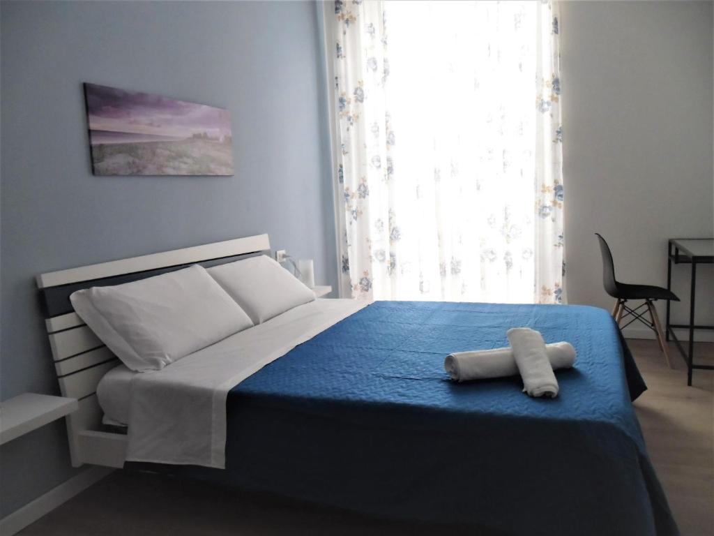 1 dormitorio con 1 cama con manta azul en Le vie del Centro, en Palermo