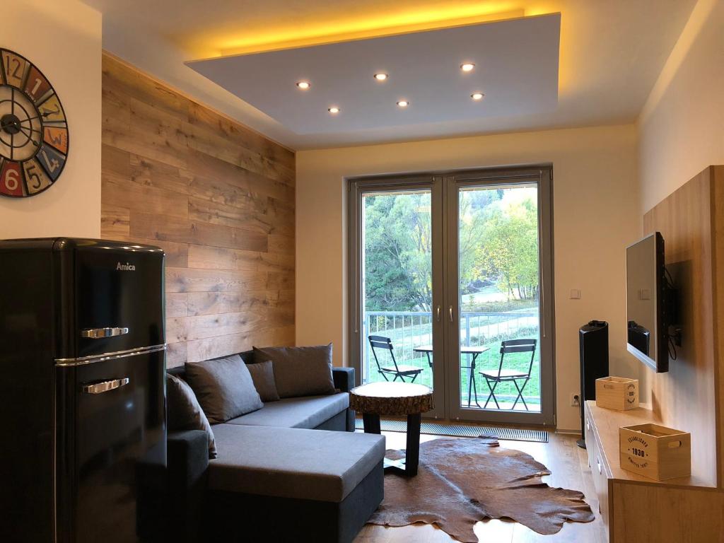 a living room with a couch and a table at Apartmán Jestřáb č.15 in Janske Lazne