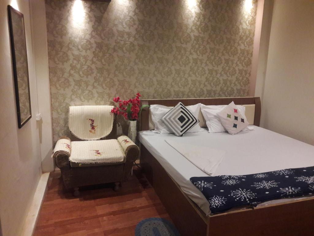 1 dormitorio pequeño con 1 cama y 1 silla en Buddha Guest House, en Varanasi