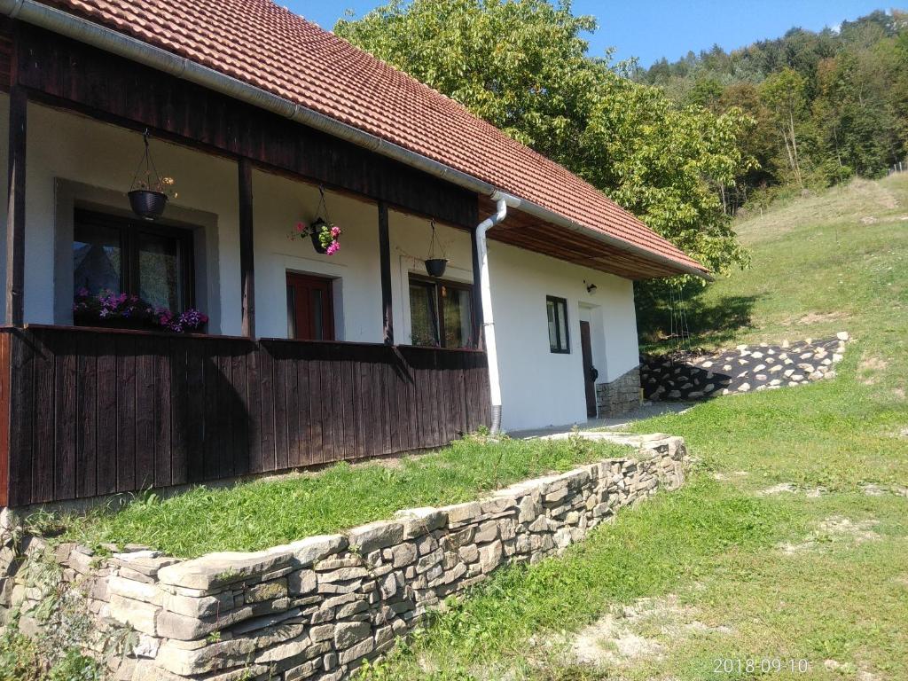 a house with a stone wall next to a building at Apartmán Beskydy in Halenkov