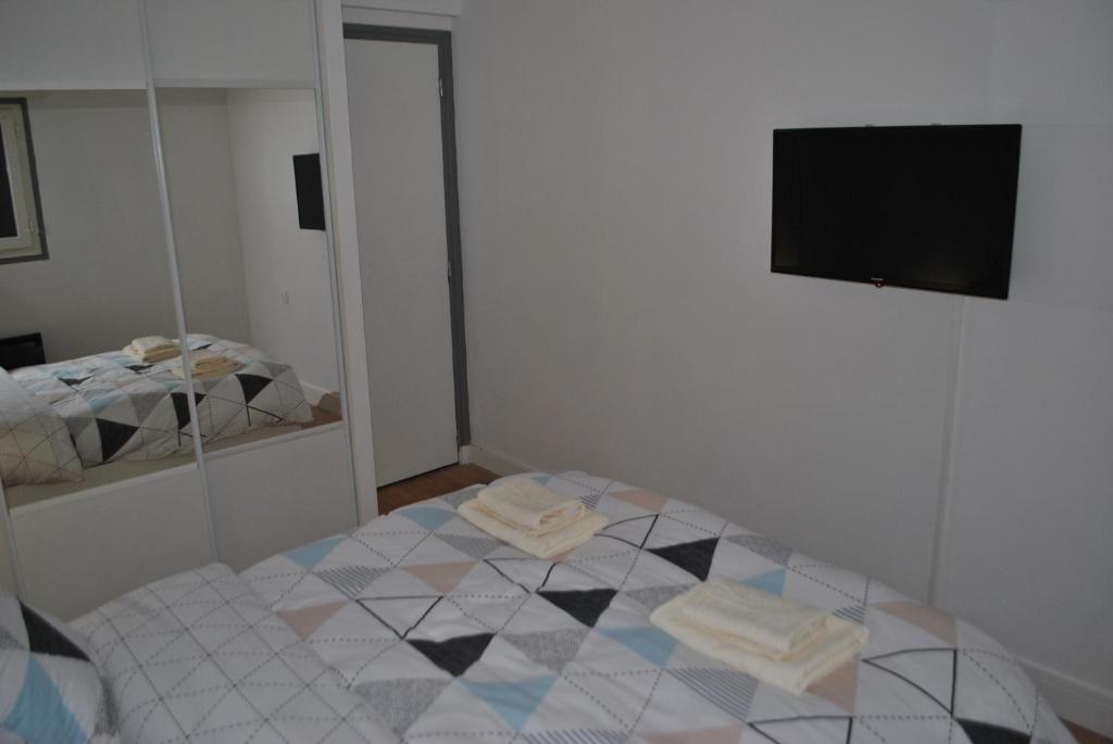 a room with a bed and a mirror and a television at appartements T2 ou T3 idéalements situés in Brech