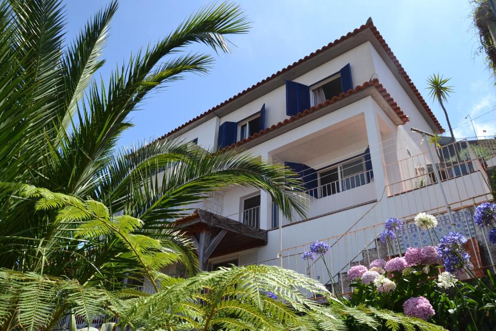 a building with palm trees in front of it at Holiday House 4 You in Funchal