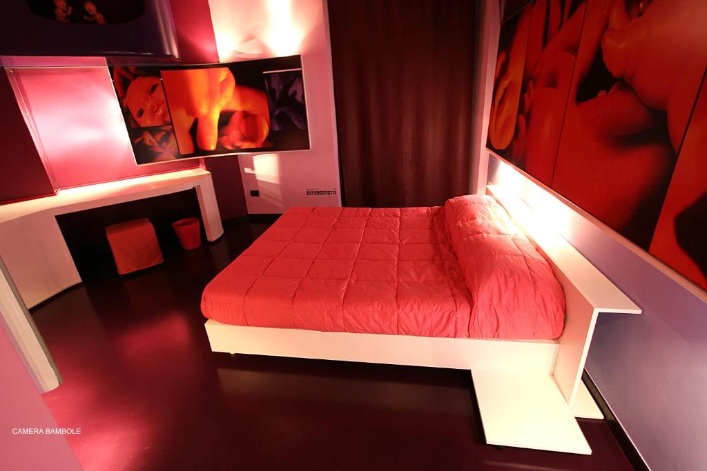 a bedroom with a red bed in a room at Diecizero Affittacamere in Barùmini
