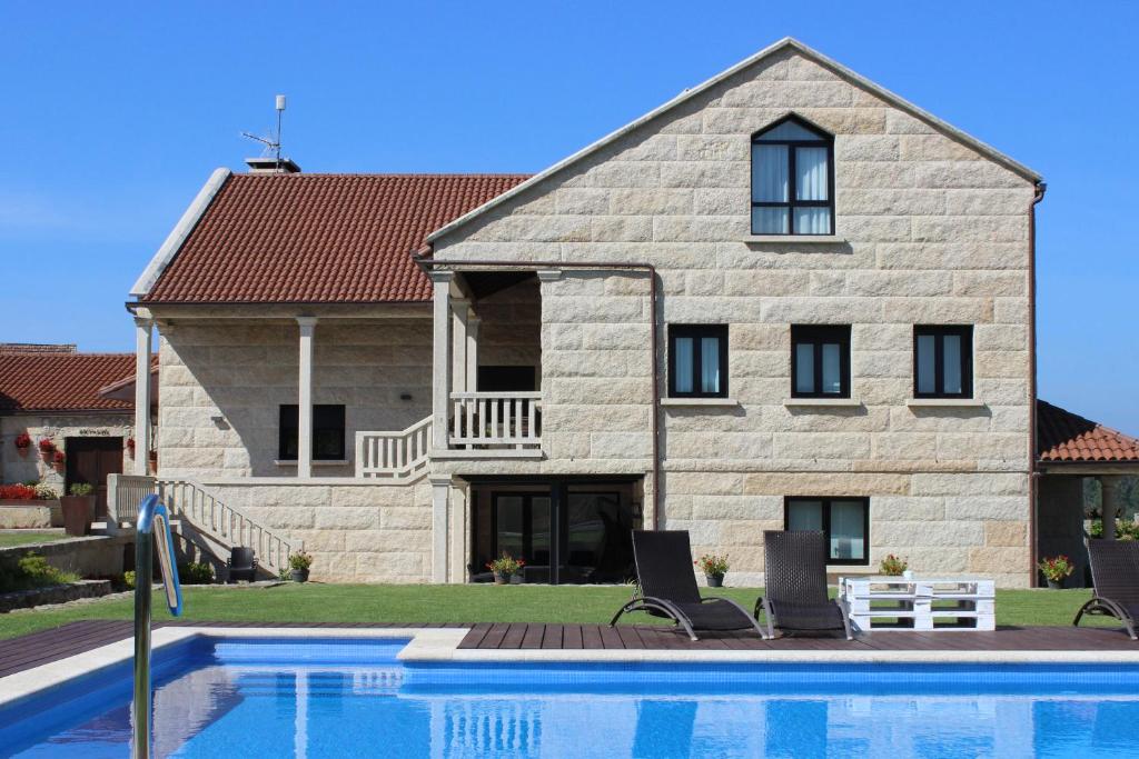 a house with a swimming pool in front of it at Enoturismo Lagar De Costa in Castrelo