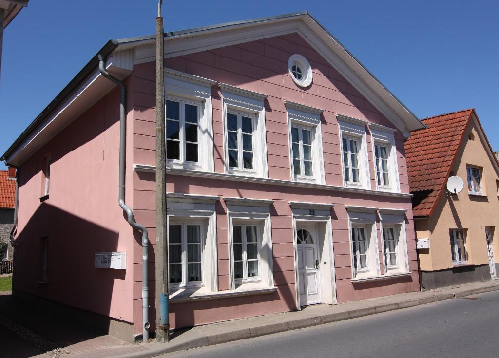 un bâtiment rose sur le côté d'une rue dans l'établissement Appartmenthaus Gingst, à Gingst