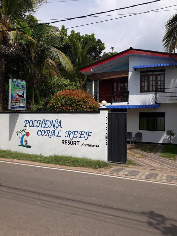 a building with a sign for a resort at Polhena Coral Reef Resort in Matara