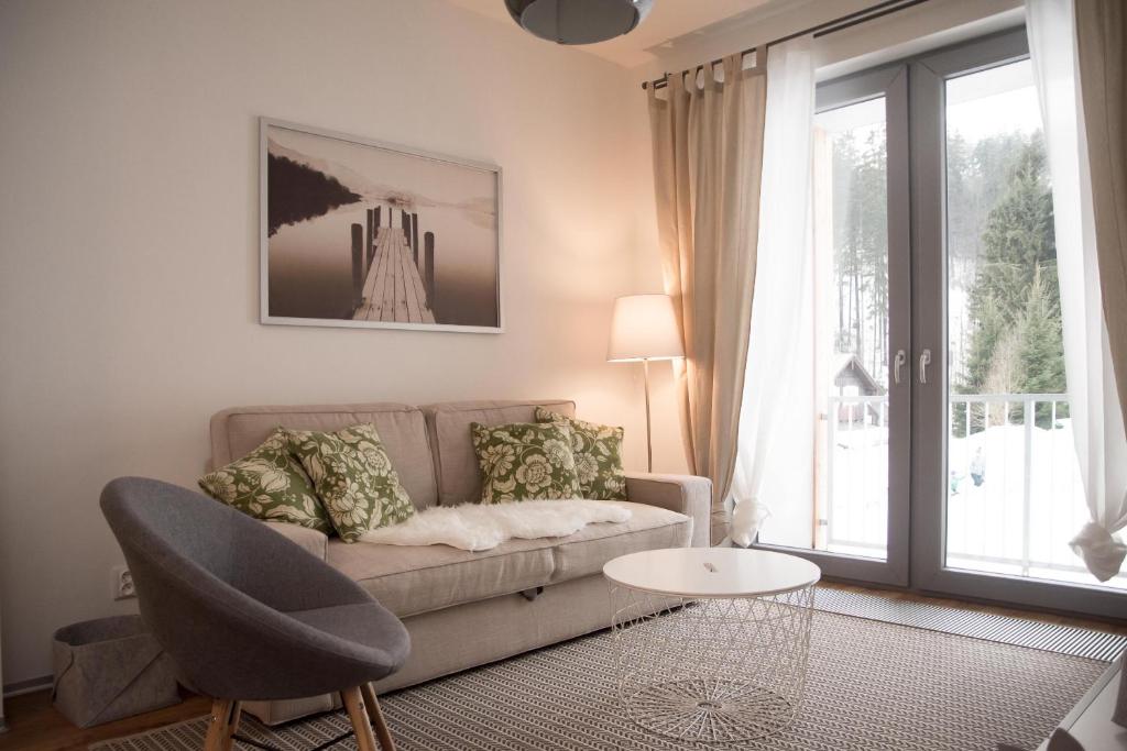 salon z kanapą i stołem w obiekcie Apartmán Jestřáb 5 w Jańskich Łaźniach