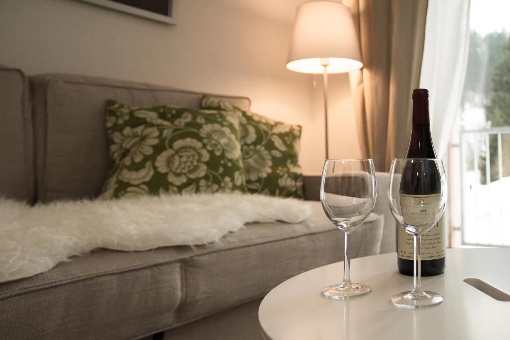 butelkę wina i dwa kieliszki wina na stole w obiekcie Apartmán Jestřáb 5 w Jańskich Łaźniach