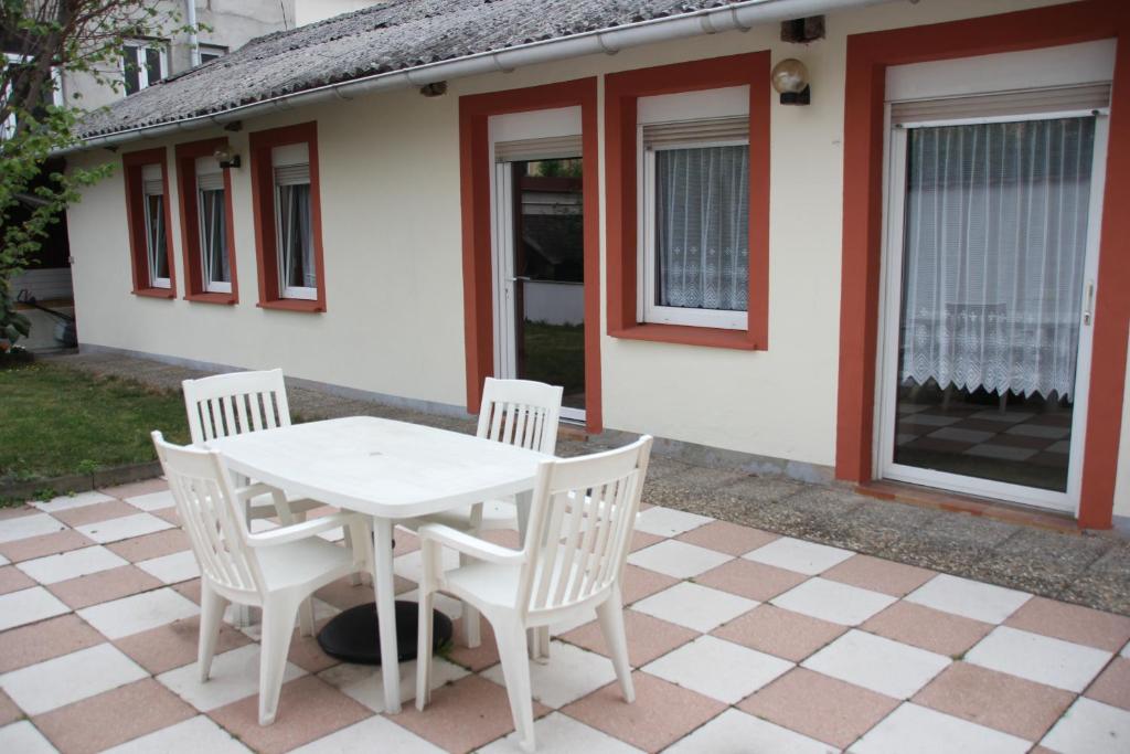 - une table et des chaises blanches sur la terrasse dans l'établissement Meublé Le Coin Tranquille, à Saverne
