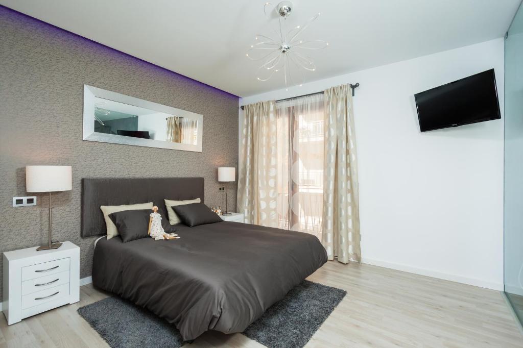 een slaapkamer met een groot bed en een televisie bij Mafloras Luxury&Beach Apartment in Son Servera