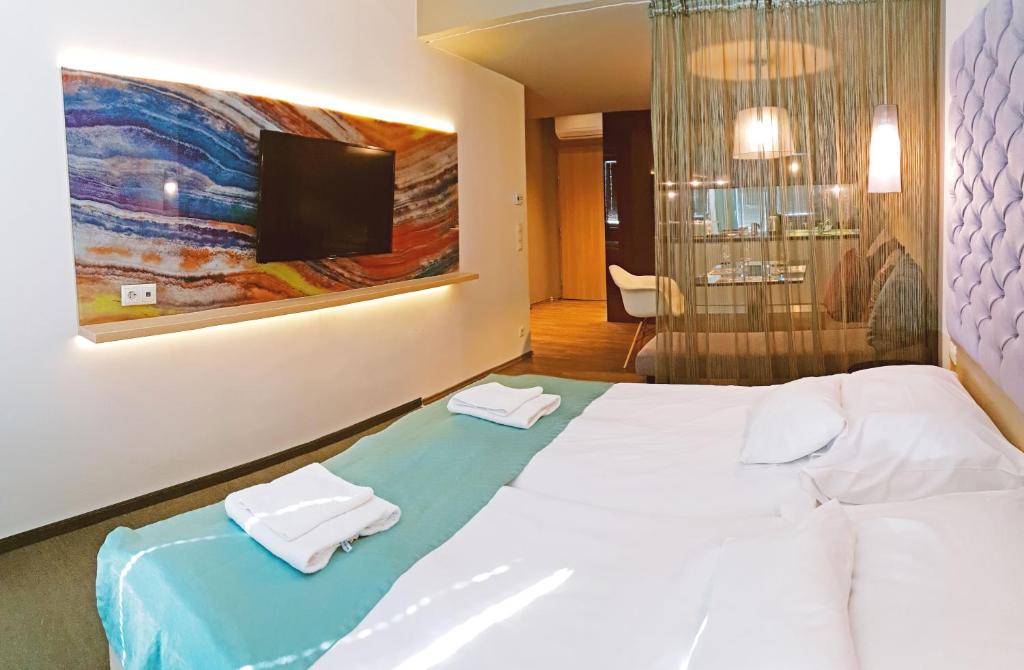 una camera da letto con un letto e due asciugamani di Orion Apartman a Sárvár
