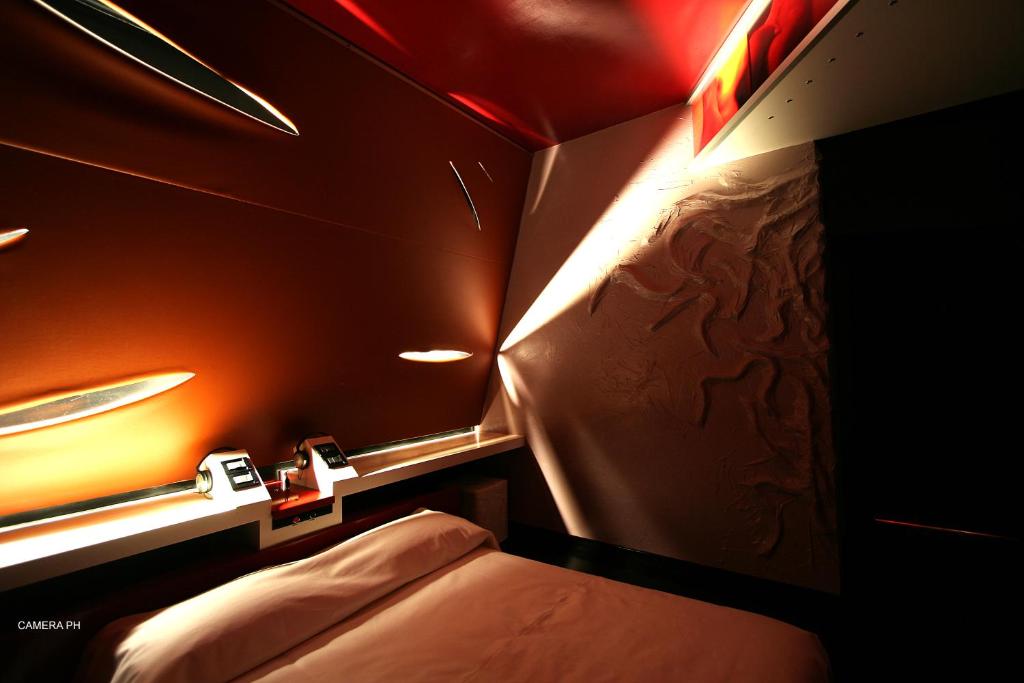 um pequeno quarto com uma cama e uma luz em Diecizero Affittacamere em Barùmini