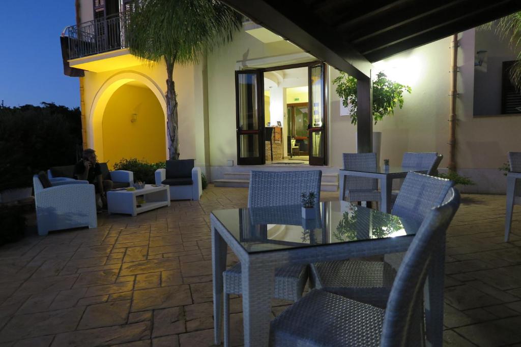 patio ze stołem i krzesłami oraz budynek w obiekcie Trigrana Vacanze Hotel w mieście Castelluzzo