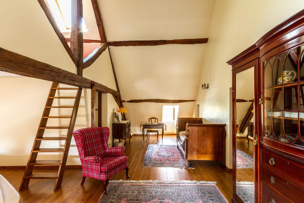 een woonkamer met een ladder en rode stoelen bij Le Fassardy in Châteauroux