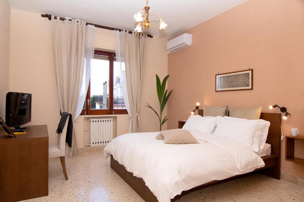 een slaapkamer met een groot wit bed en een raam bij B&B Syrentum in Sorrento