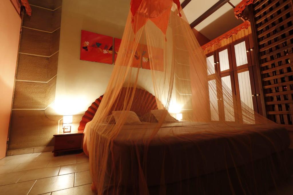 a bedroom with a bed with a mosquito net at Les Nids de Belle Eau in Capesterre-Belle-Eau
